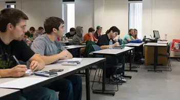 Student sitting in a classroom taking notes