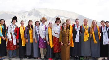 A group of people in standing in front of a mountain
