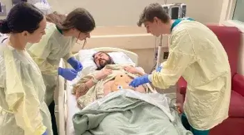 Nursing students work with standardized patient in simulation
