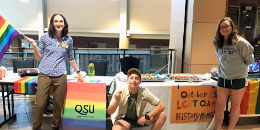 Prism Center staff with students of QSU posing at resource table in Davis Center