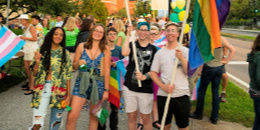 Students hold rainbow and trans flags at UVM Convocation 