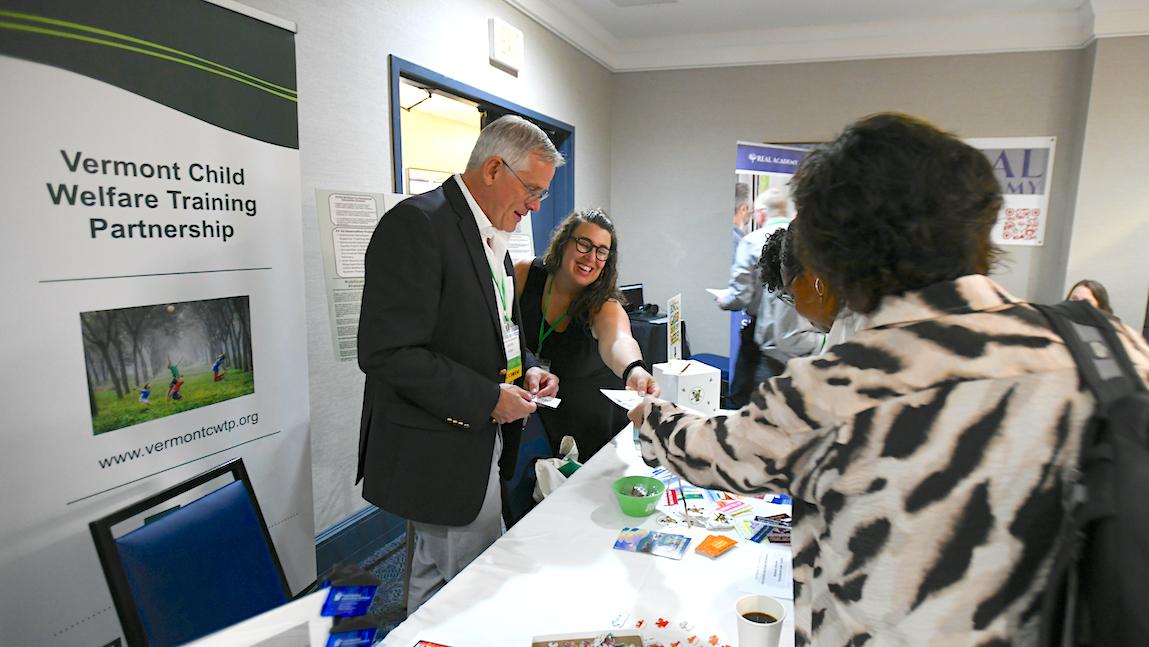 Social Work Lecturer Cassie Gillespie passes out information about The Social Work Lens podcast to conference attendes at the national Title IV-E Roundtable event hosted by the University of Vermont.