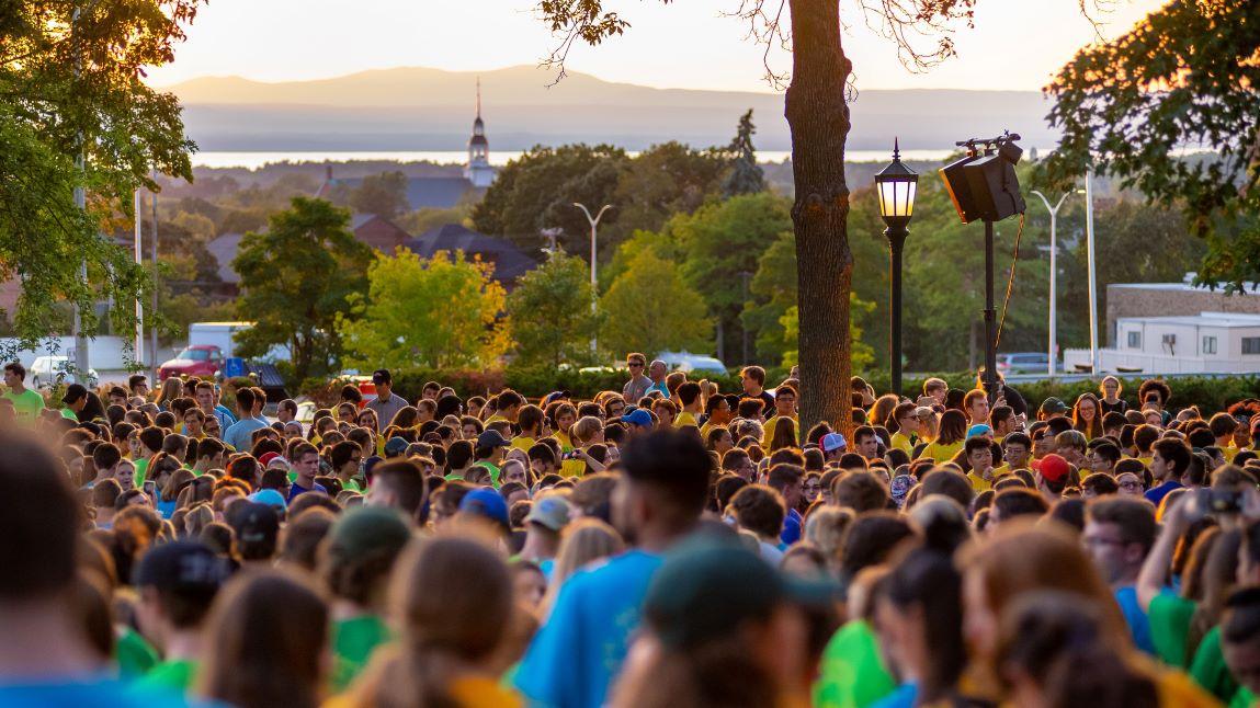 Students and UVM community gathering outside at sunset for Convocation