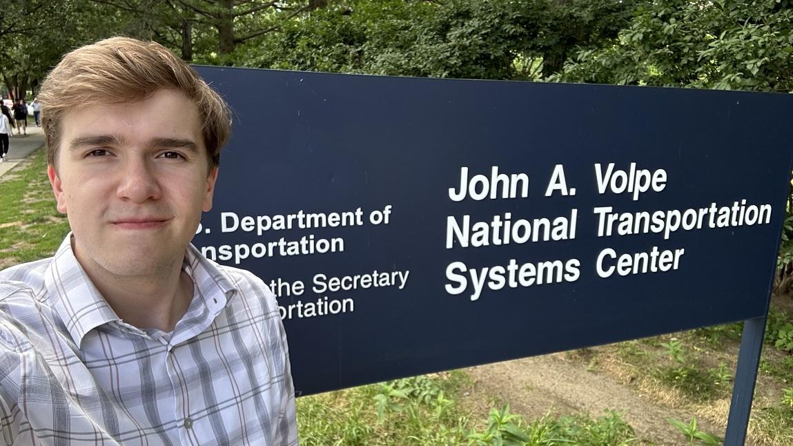 Chris Lamm standing in front of a Department of Transportation sign