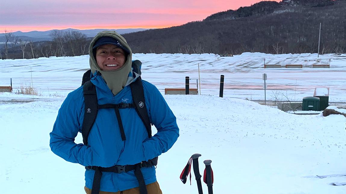 Andrew Romano stands in snow-covered, empty ski resort parking lot at sunrise