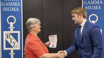 New grossman BGS member shaking hands with the Dean