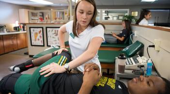 a person adjusts a student's hip