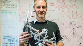 Josh Bongard holding a robotic model