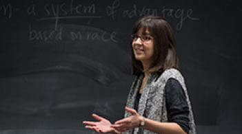 A teacher giving a lecture in front a black board