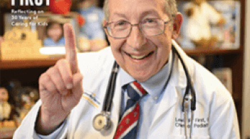 smiling doctor holding up index finger