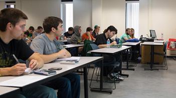 Student sitting in a classroom taking notes