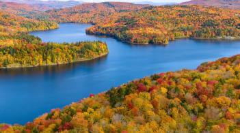 Fall foliage around a blue lake.