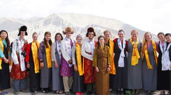 A group of people in standing in front of a mountain 