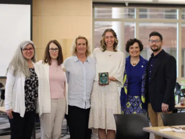 Award recipient poses with five faculty members