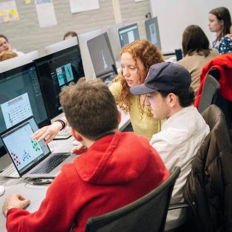 Students work together on laptops in a classroom