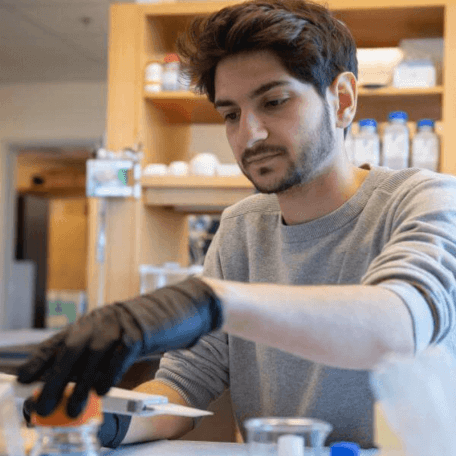 A student uses a pipette tool in a lab