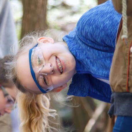 girl with braces and lab goggles smiling at the camera