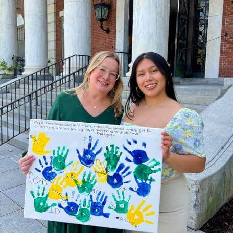 AMP graduate and faculty mentor hold a poster given by students.