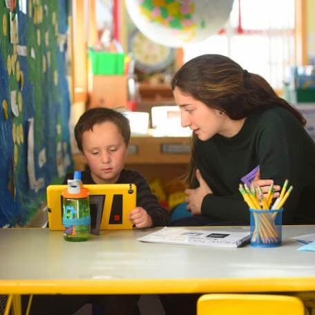 Student teaching intern works with a child in an elementary school classroom.