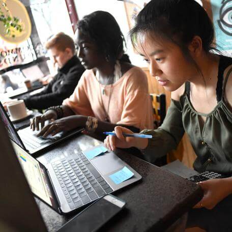 Student working on laptops at a cafe