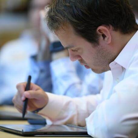 Adult learner writing on tablet