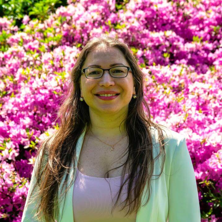 Masha is standing in front of the pink blossoms