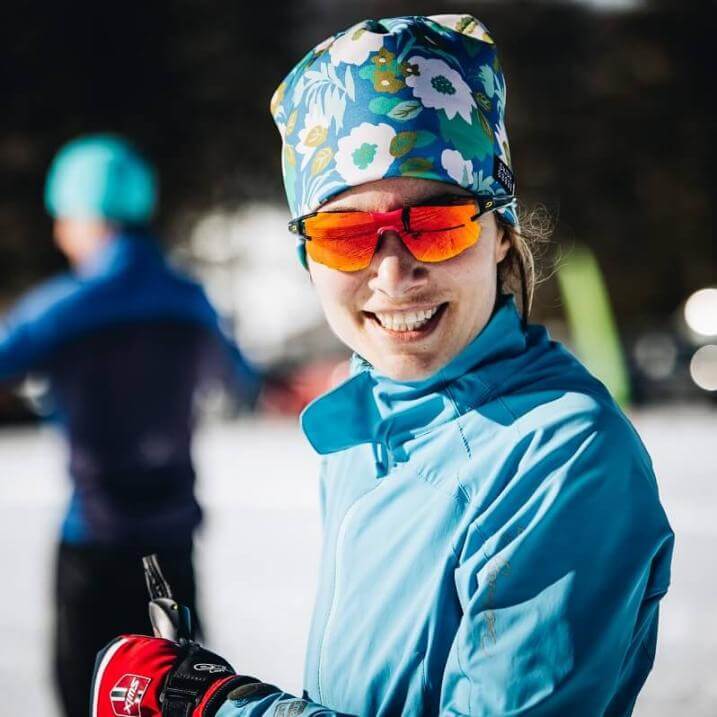 Kim Coleman outside dressed for nordic skiing, wearing sunglasses and smiling