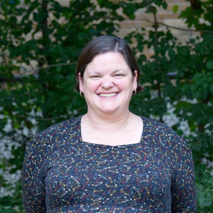 Melissa Murray smiling while standing in front of greenery