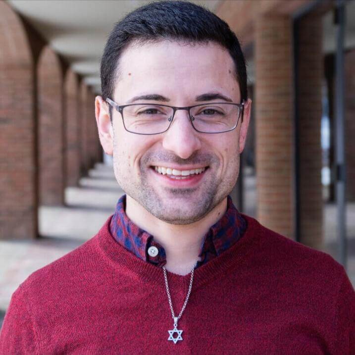 Evan Cuttitta is smiling in front of Grossman Building