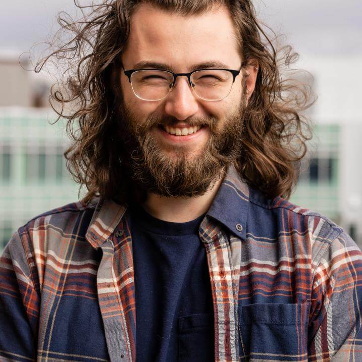 Photo of Will smiling outside the Davis Center, with his hair doing a lot of fun and interesting things in the wind 