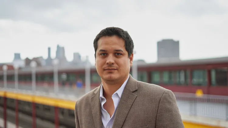 headshot of a man against a city skyline