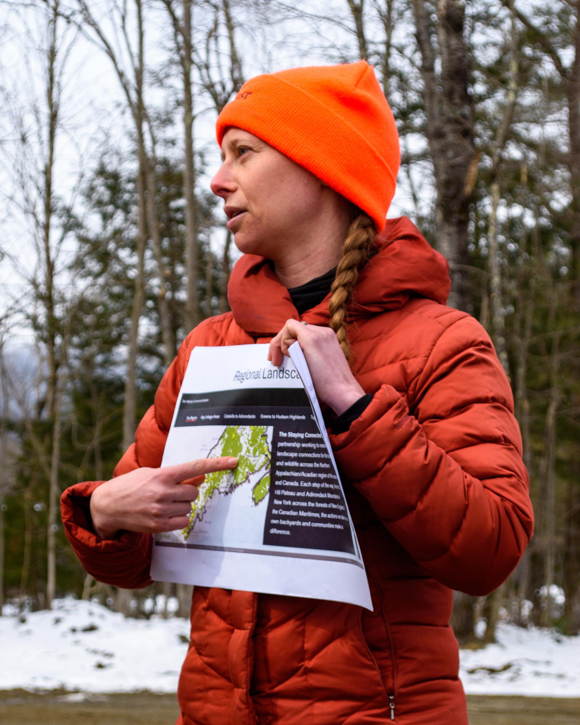 carolyn loeb holds a map of the adams camp connector project