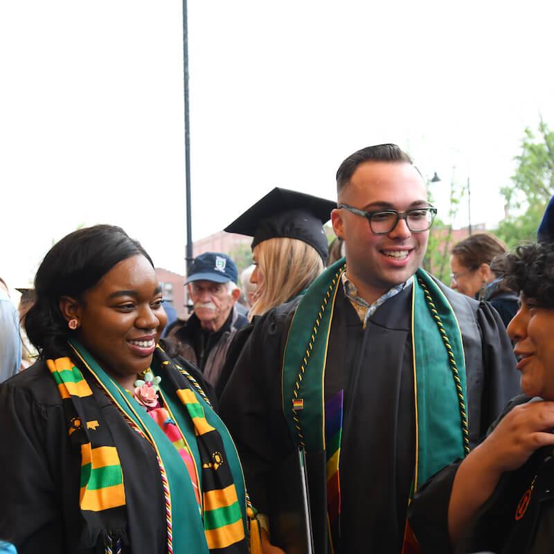 Graduates and faculty smiling and talking after CESS Commencement.