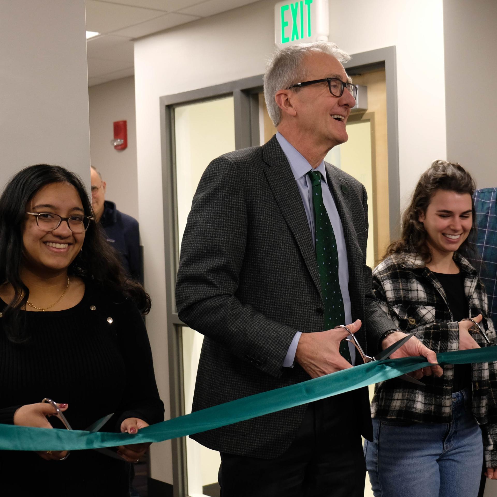 man holding scissors cutting ribbon