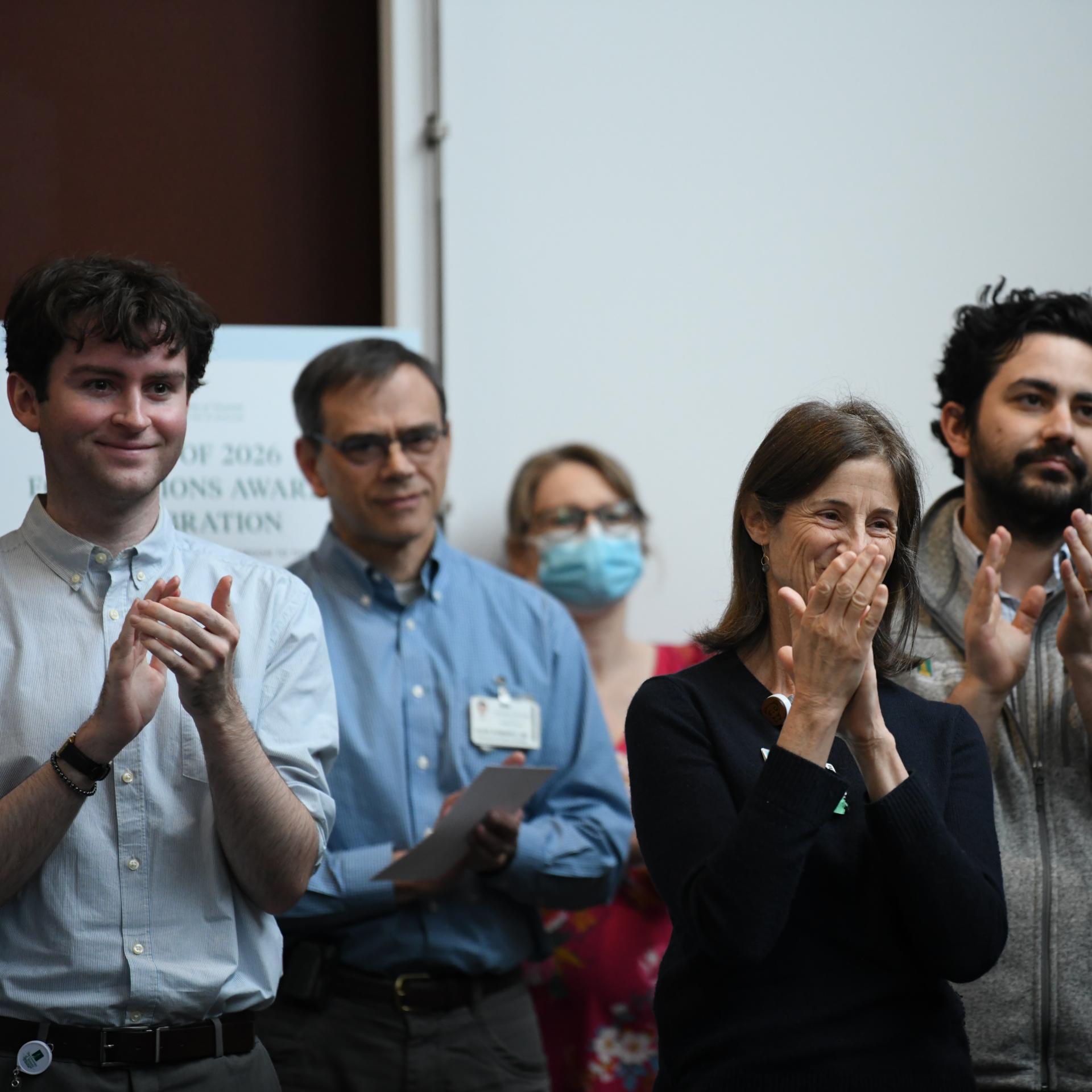 Members of a crowd clapping