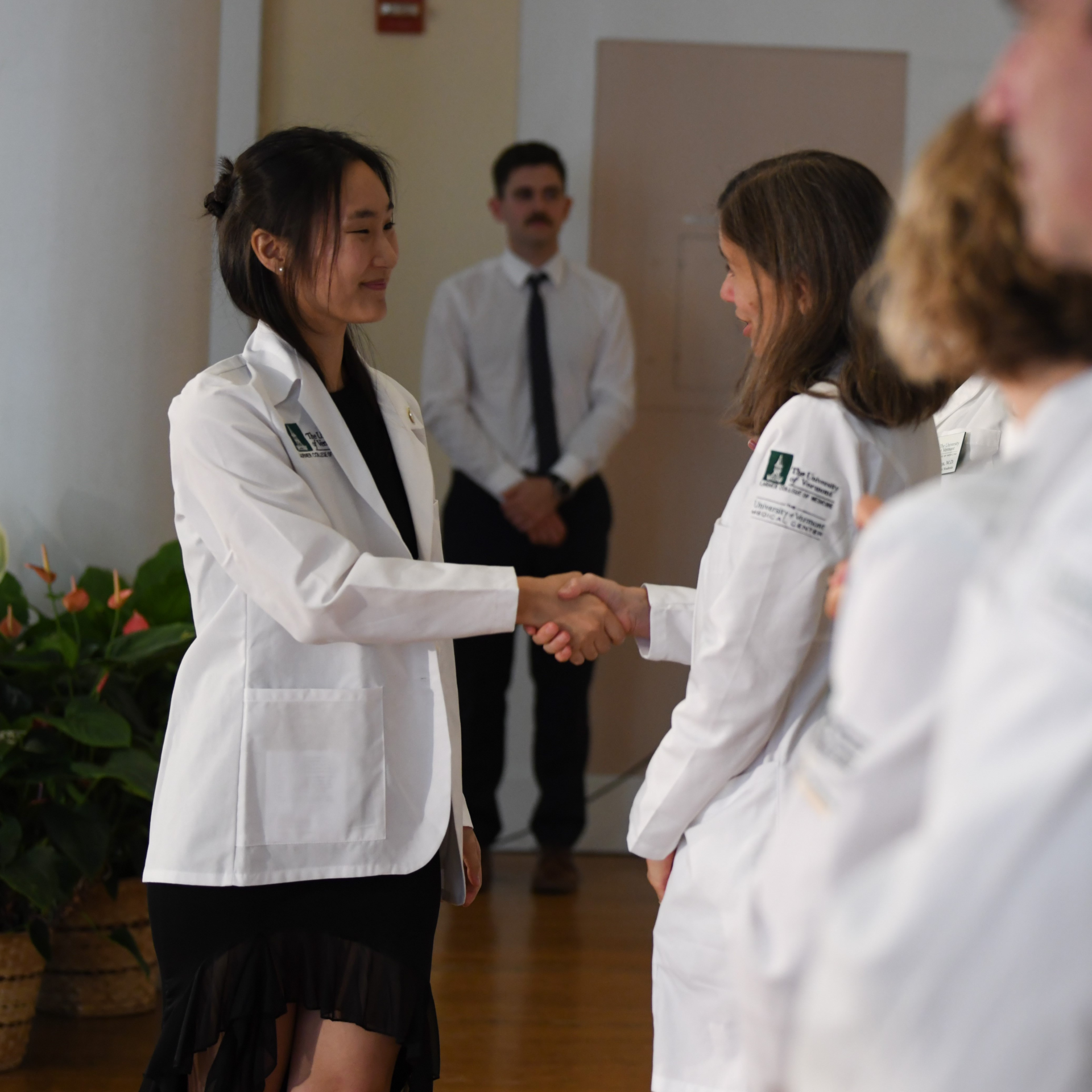 Two people shaking hands at ceremony