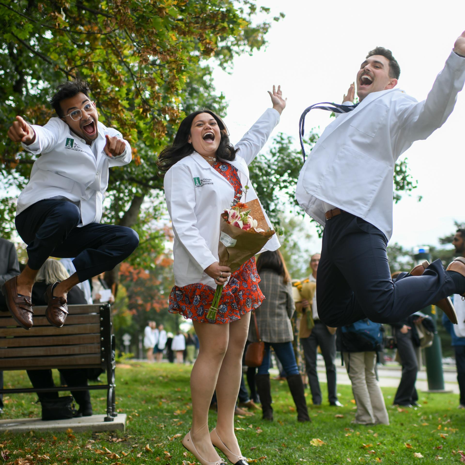 Students wearing white coats jumping