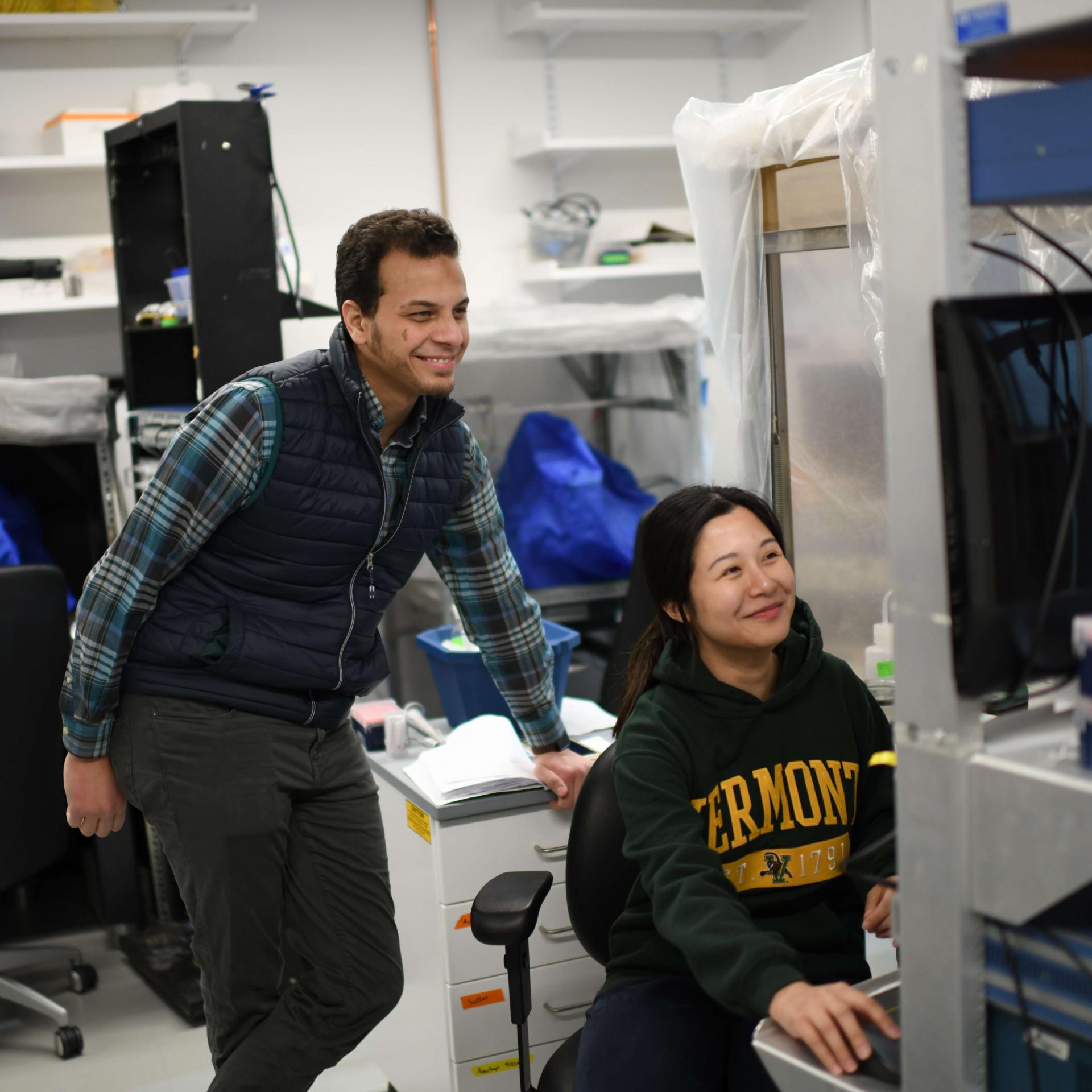 Two people in lab looking at computer