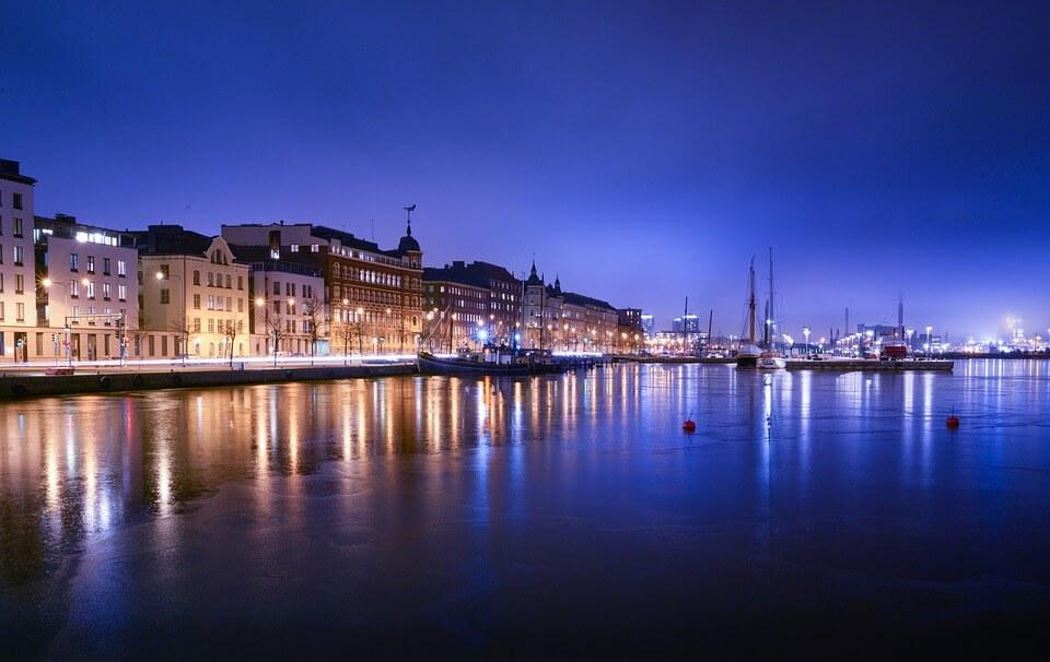 Helsinki buildings reflecting along the waterfront at dusk. 