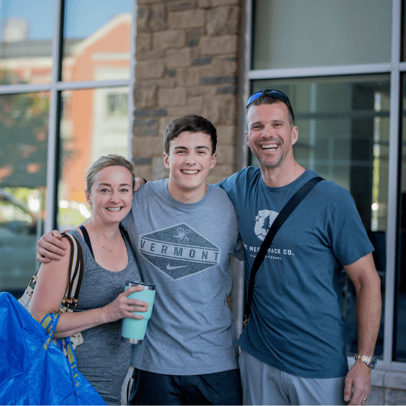 A student poses with his parents during move-in