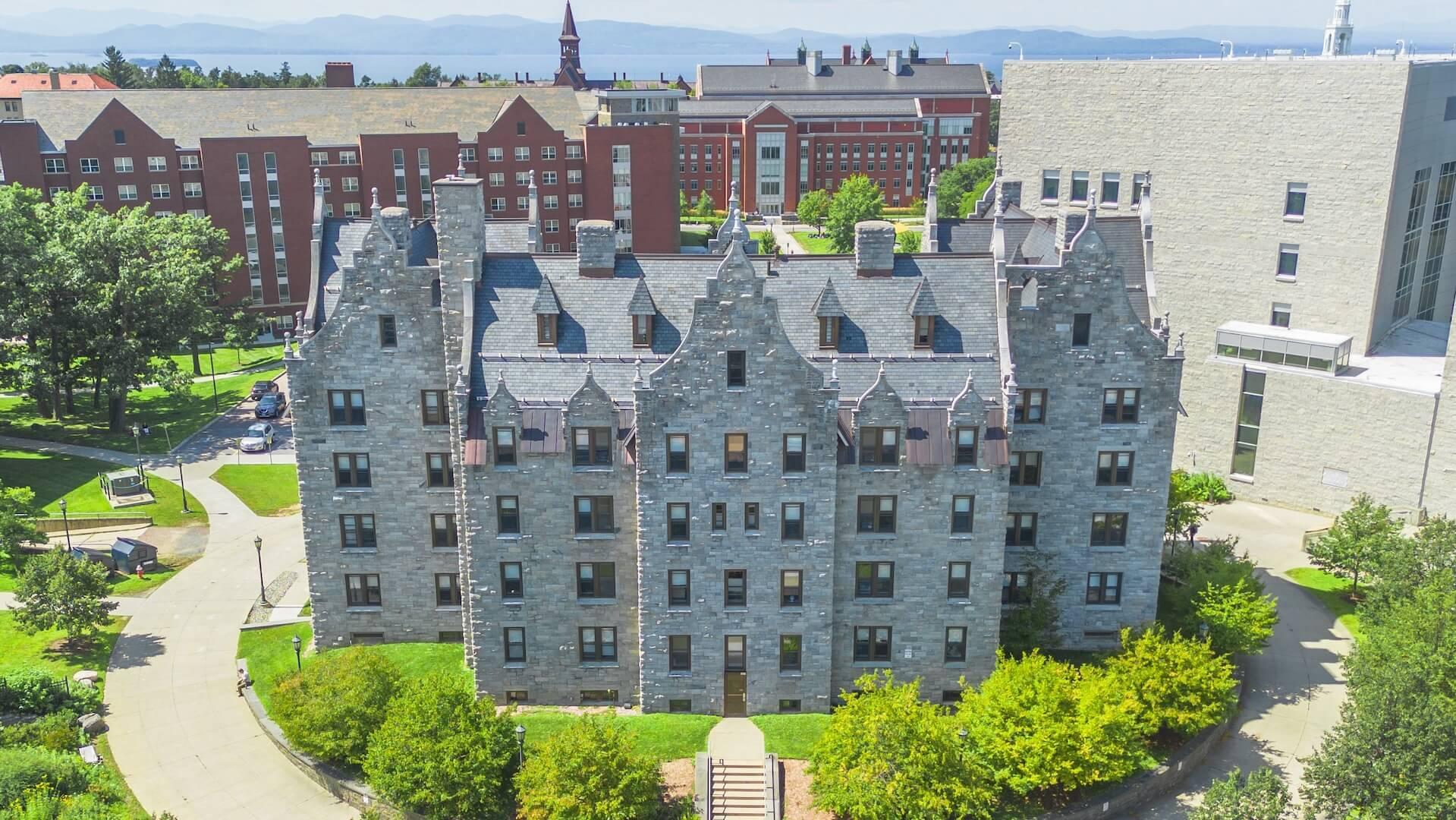 Aerial view of historic, romanesque grey stone residence hall. 