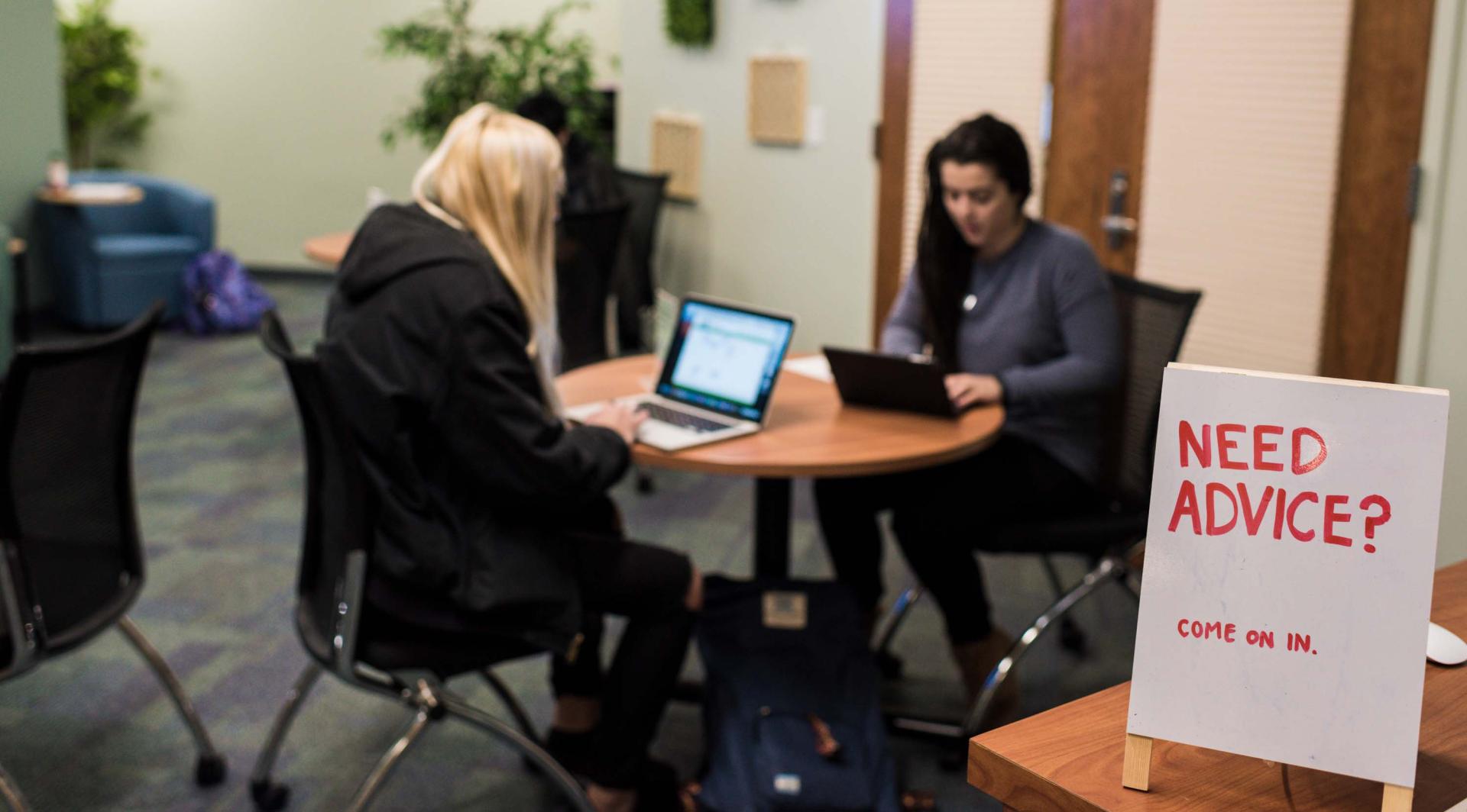 Two student seating with their laptop open