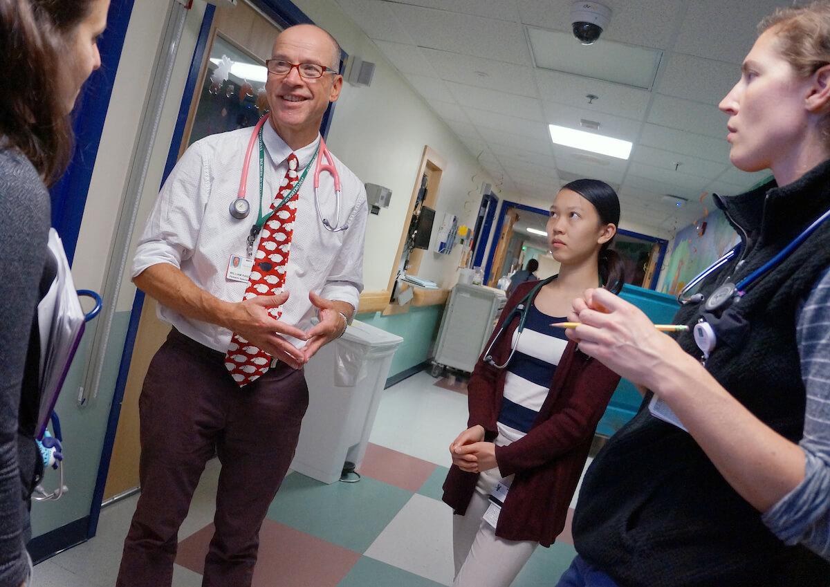 Students listening to a physician during pediatrics clerkship rounds