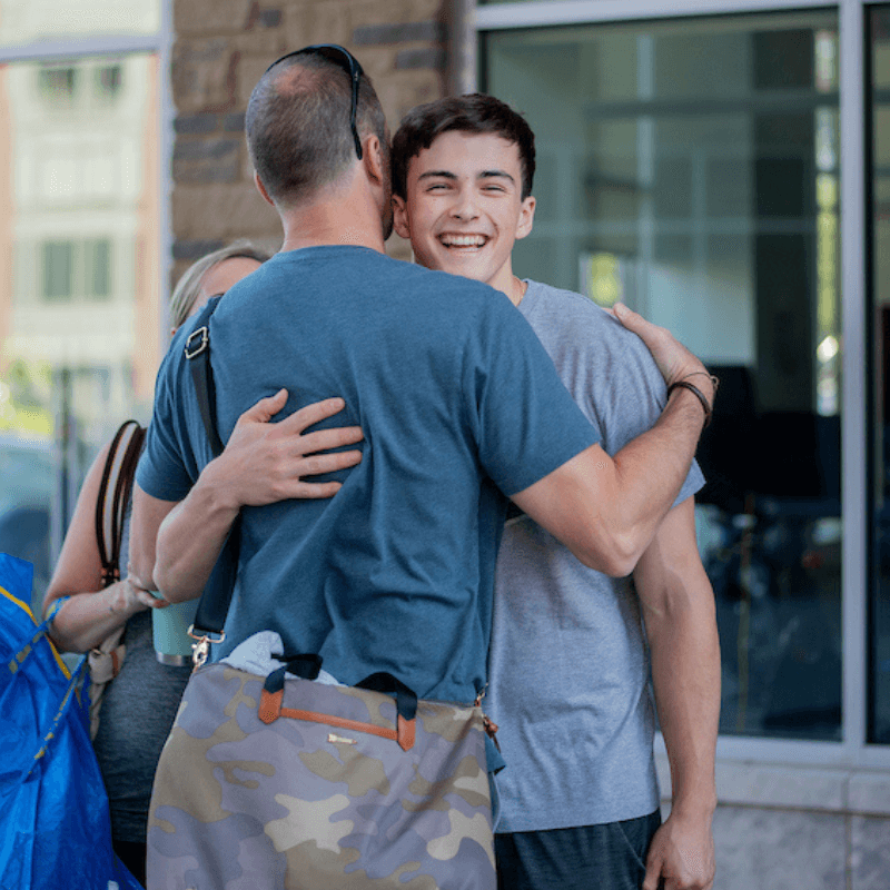 A father and son embrace during college move-in