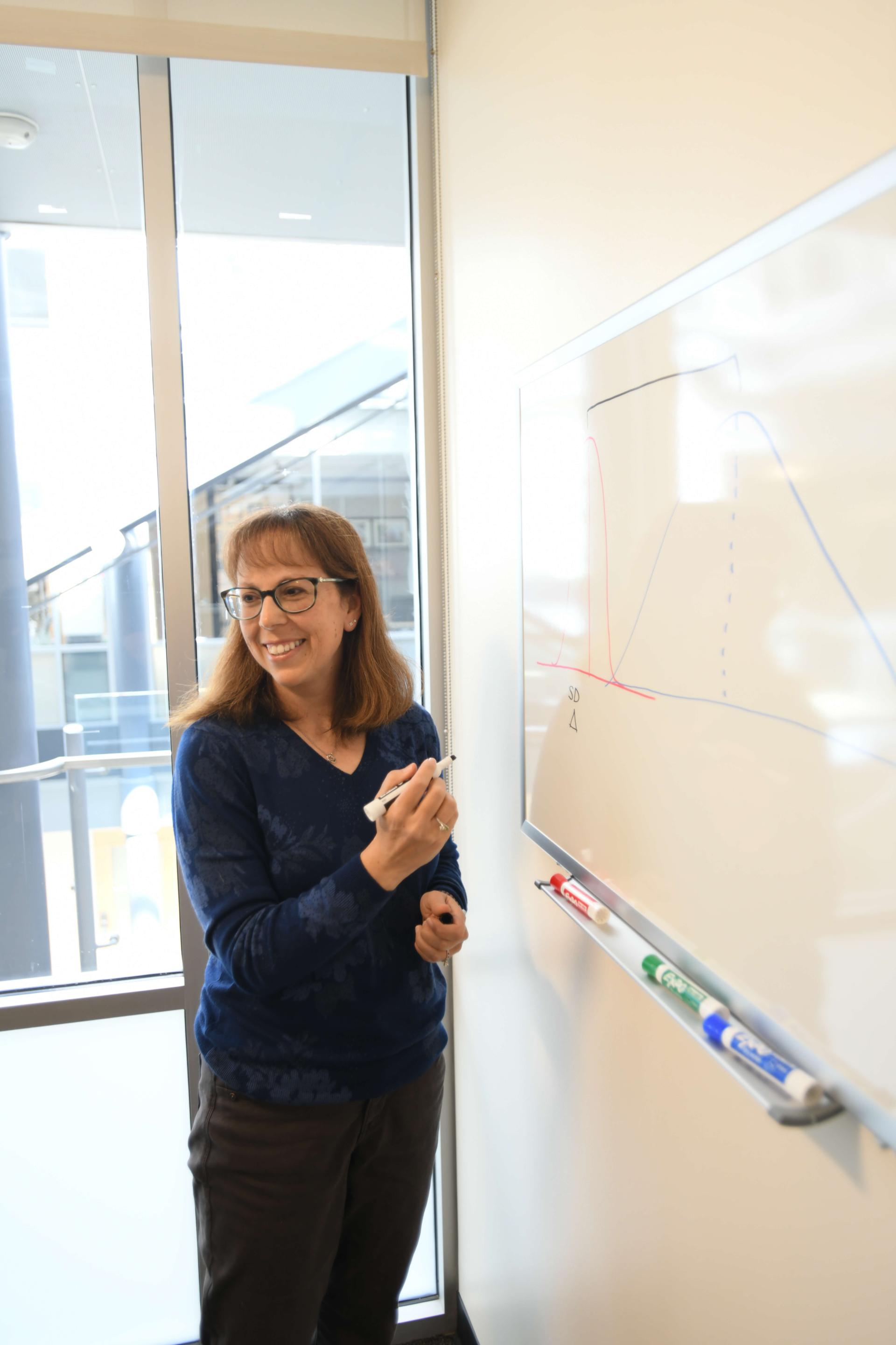 CTS professor writing at a whiteboard