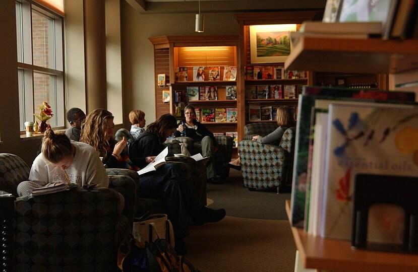 A cozy nook inside of the Davis Center, filled with books and many individuals reading