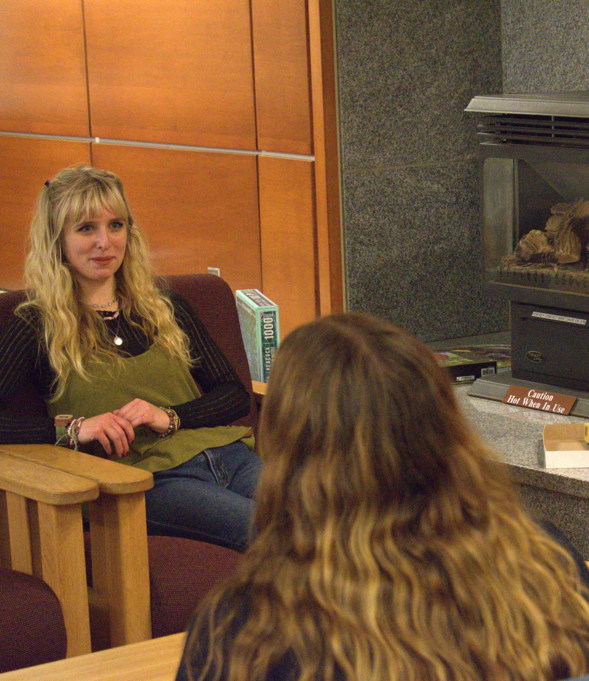 students talking in front of a fireplace