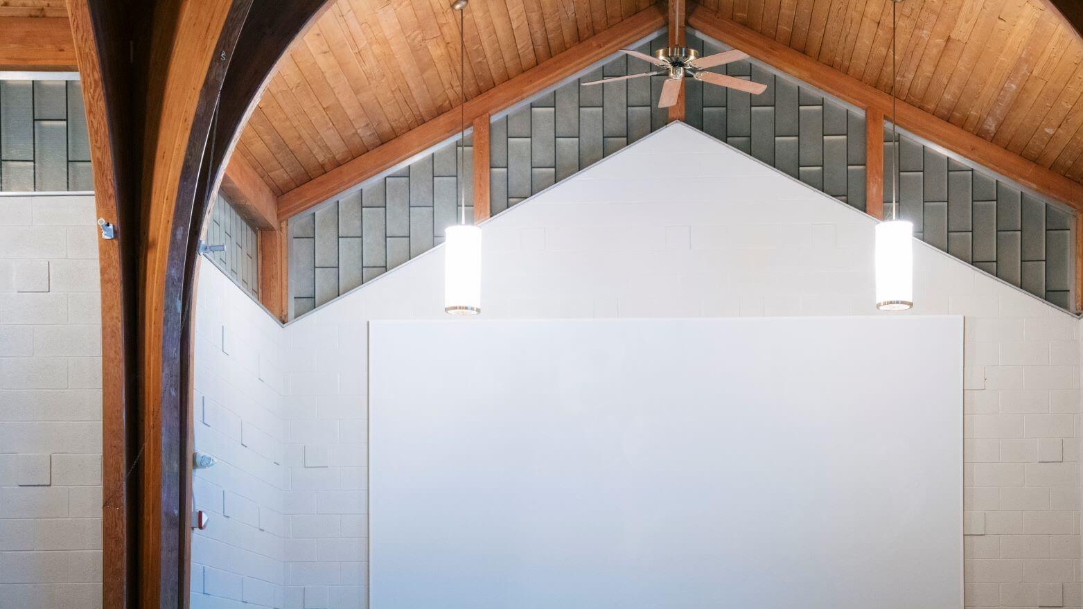 Vaulted wood ceiling of the Interfaith Center and white wall