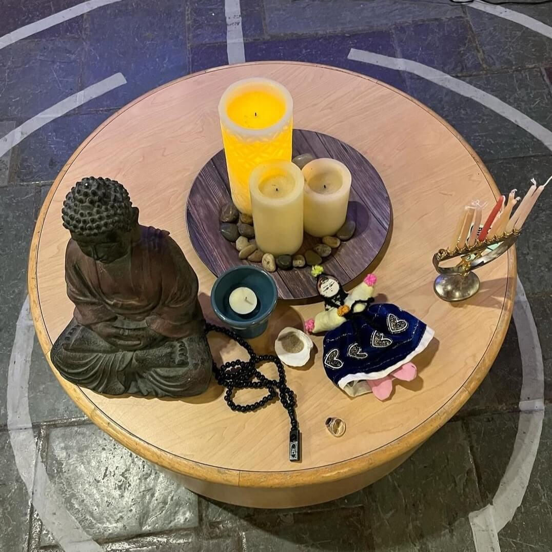 Symbols from various cultures and religions sit on top of a small, circular table in the middle of the Interfaith Center's labyrinth.