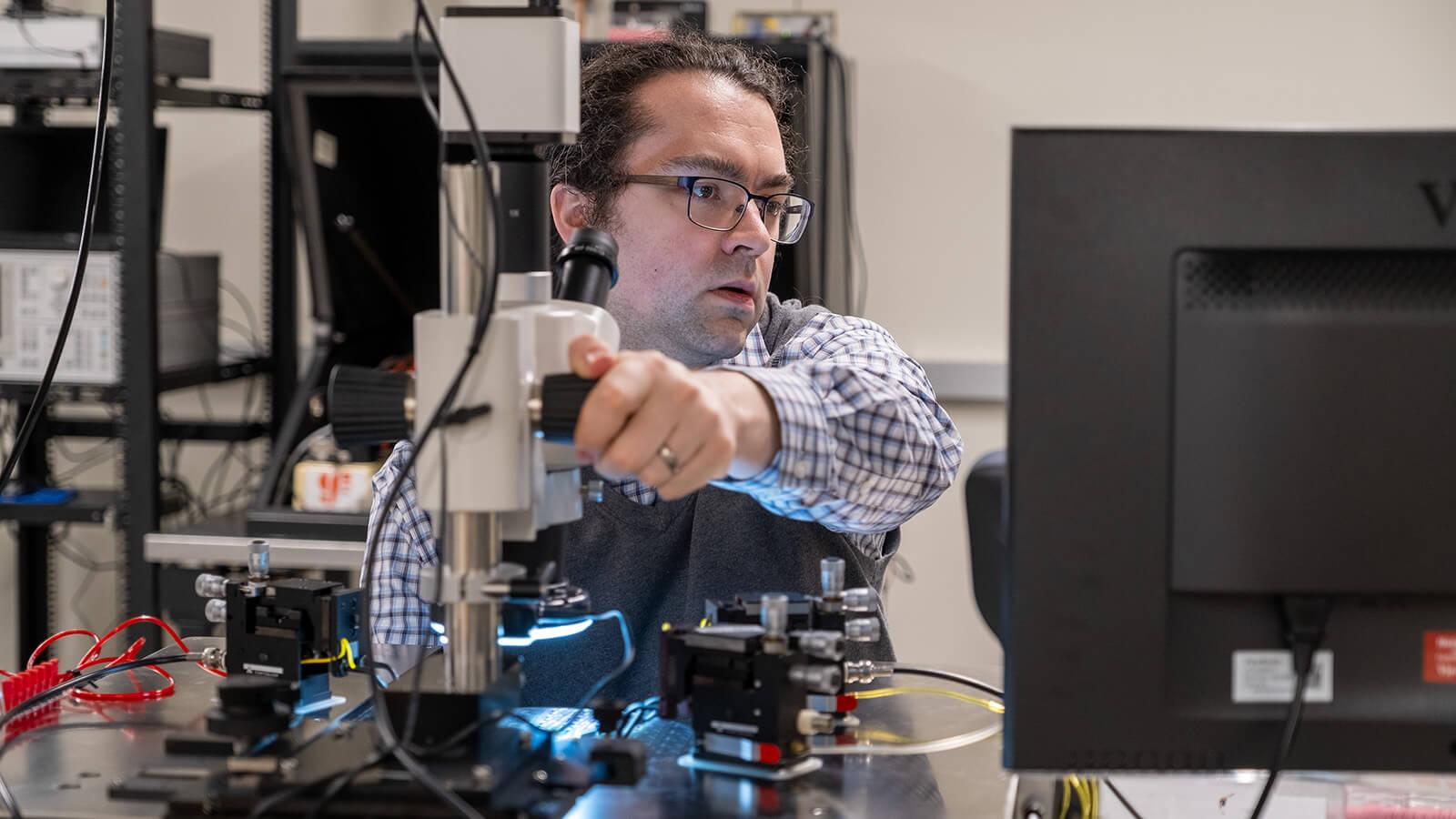 CEMS faculty adjusts equipment during semiconductor evaluation